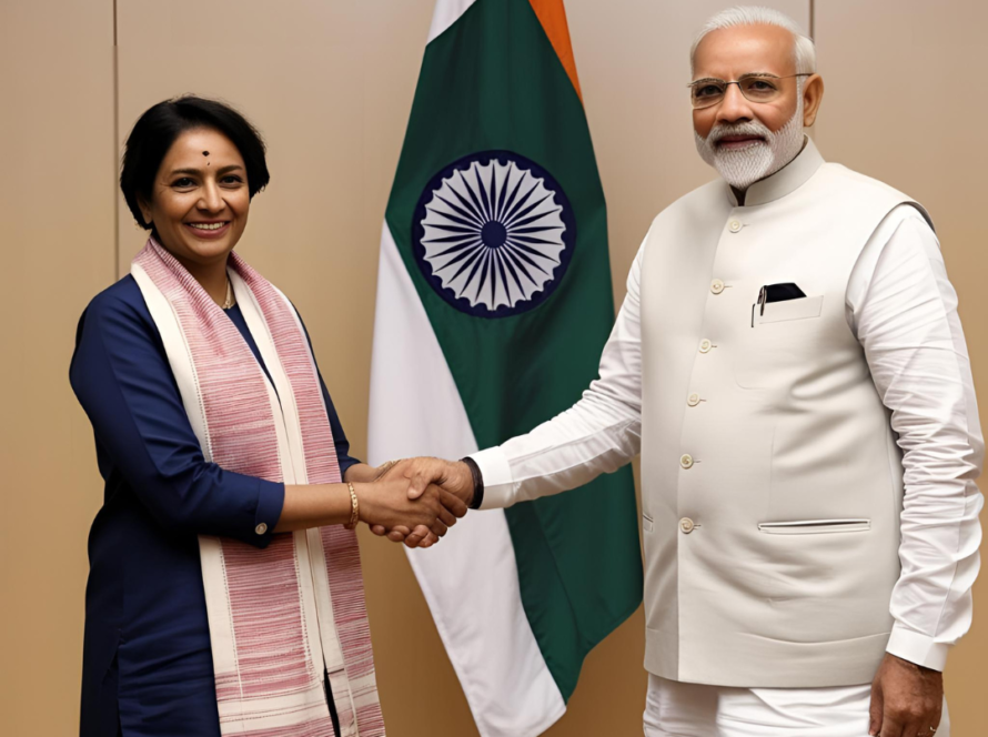 "A professional meeting between an Indian woman in traditional attire and an Indian political leader dressed in a white kurta and jacket. They are shaking hands in front of the Indian national flag, symbolizing cooperation and partnership in governance, policy, or development initiatives. The setting is a formal office or conference room, indicating an official engagement."